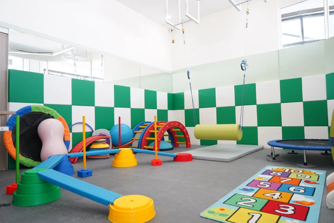 ห้องกิจกรรมบำบัด ผนังบุนุ่มสีเขียวขาว พร้อมอุปกรณ์ฝึกการทรงตัว ที่ InterRehab NeuroBridge